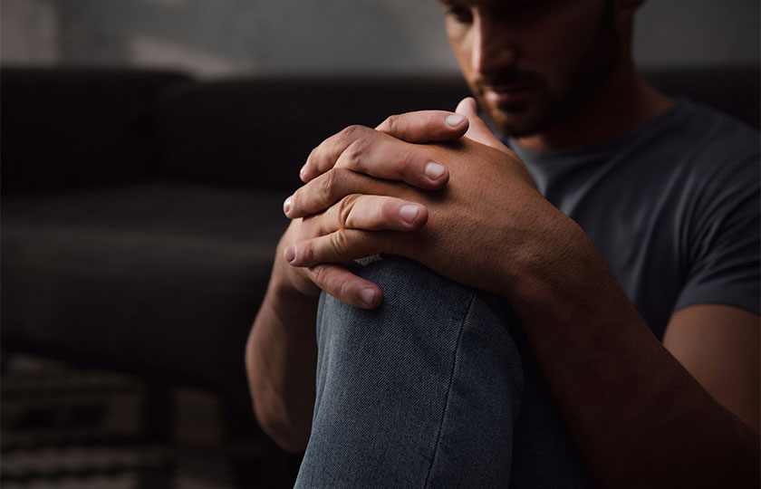 man sitting down and looking sad